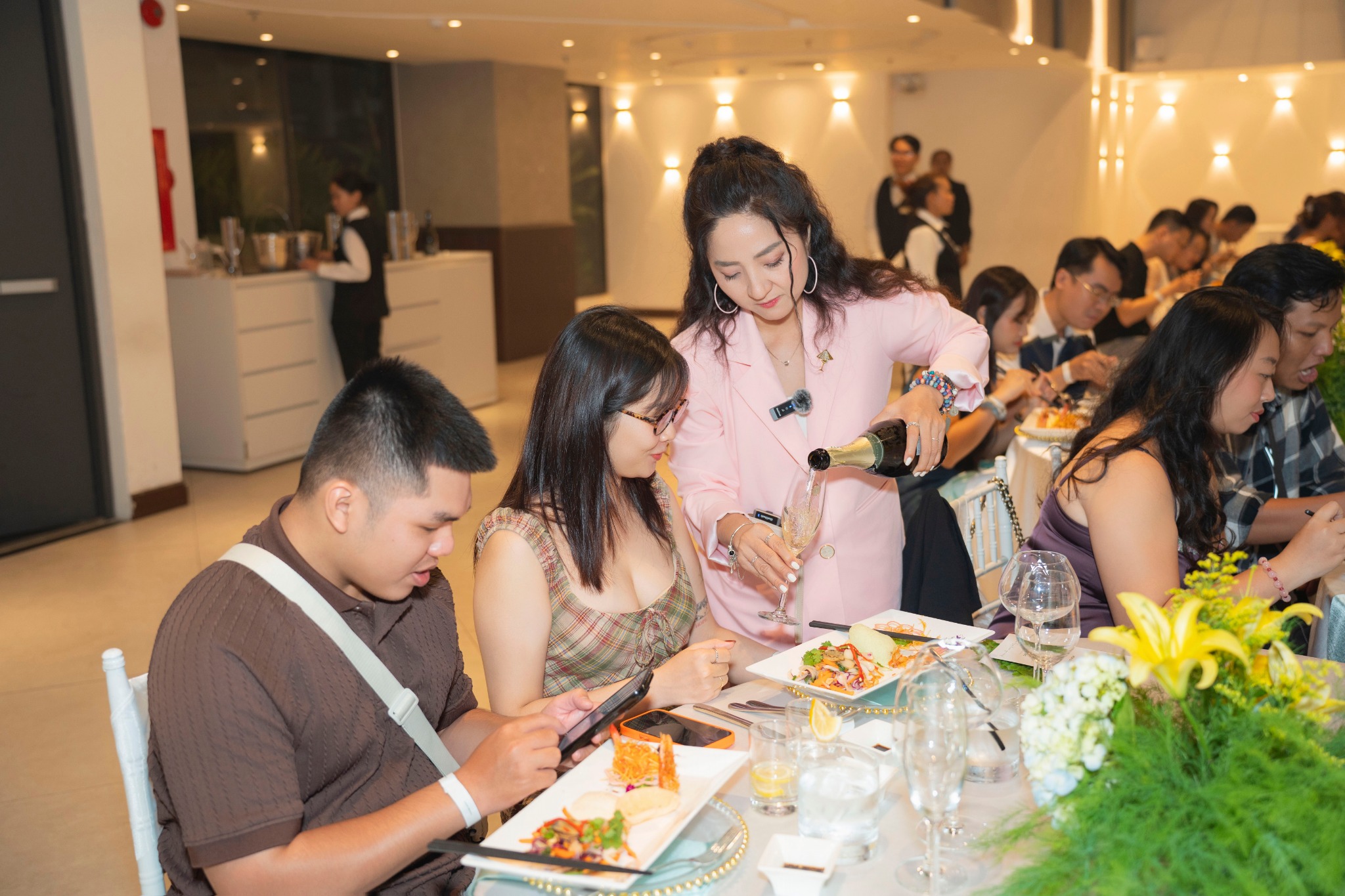 ROSEMARY phục vụ vang cho khách mời trong bữa tiệc